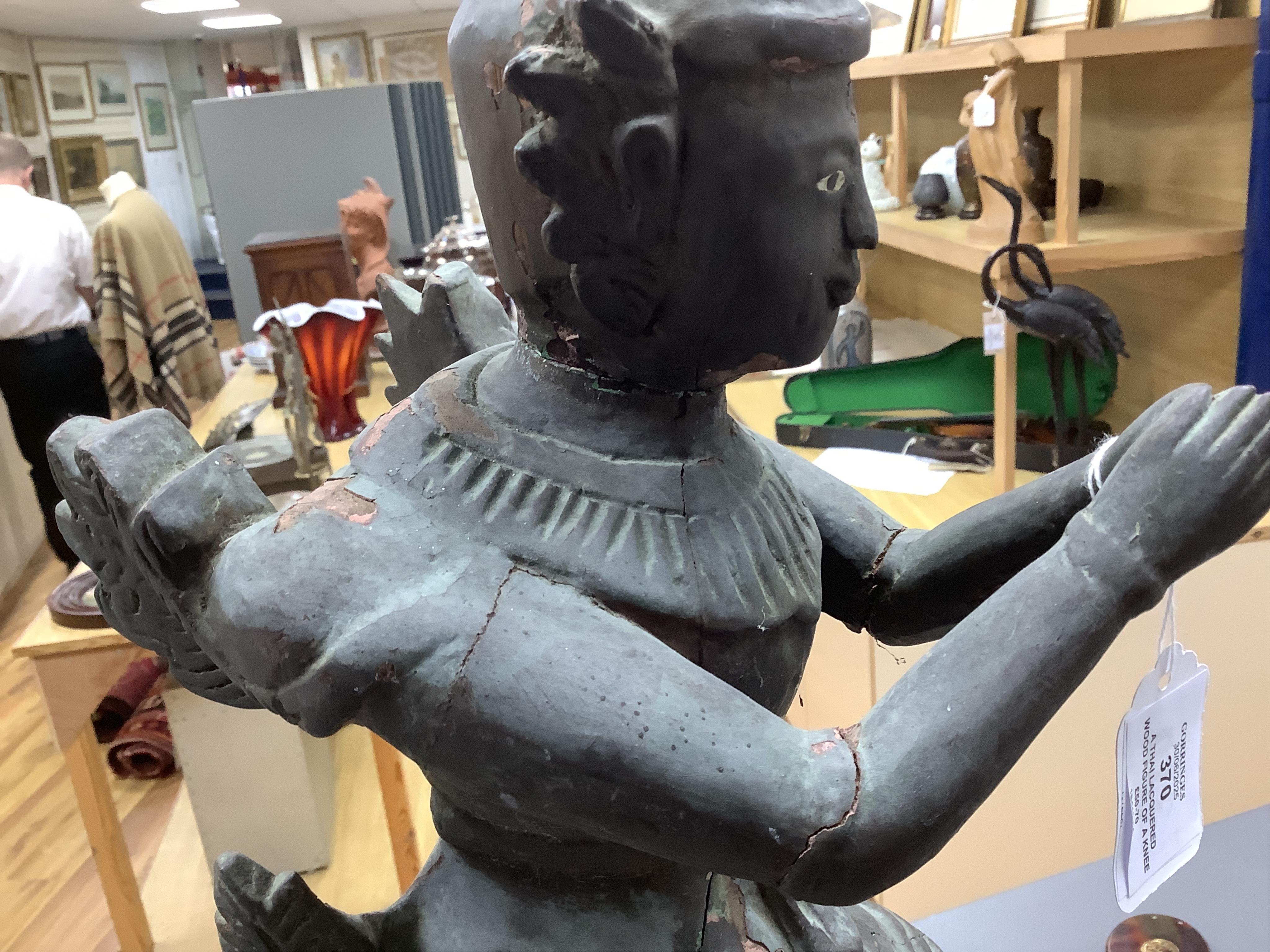 A Thai lacquered wood figure of a kneeling deity, 46cm high.